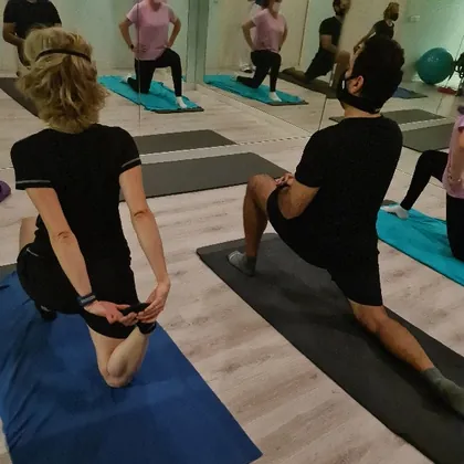 Clase de pilates en la sala de MásqueFisio: un grupo haciendo zancadas sobre esterillas