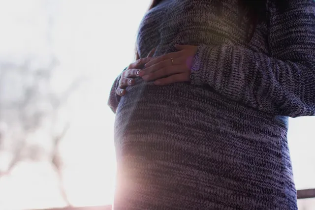 Mujer embarazada con las manos sobre la tripa