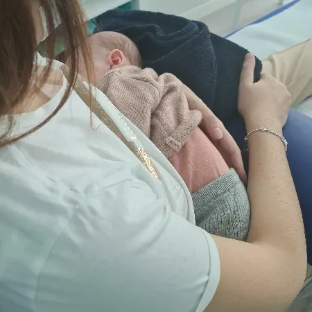 Una fisioterapeuta de la clínica con un bebé en brazos